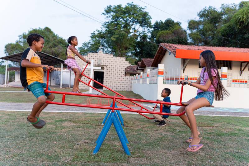 Crianças se divertem nos brinquedos na praça